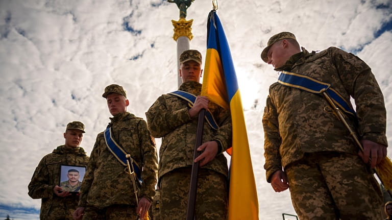 Ukrainian servicemen walk ahead of the coffin of their fallen...