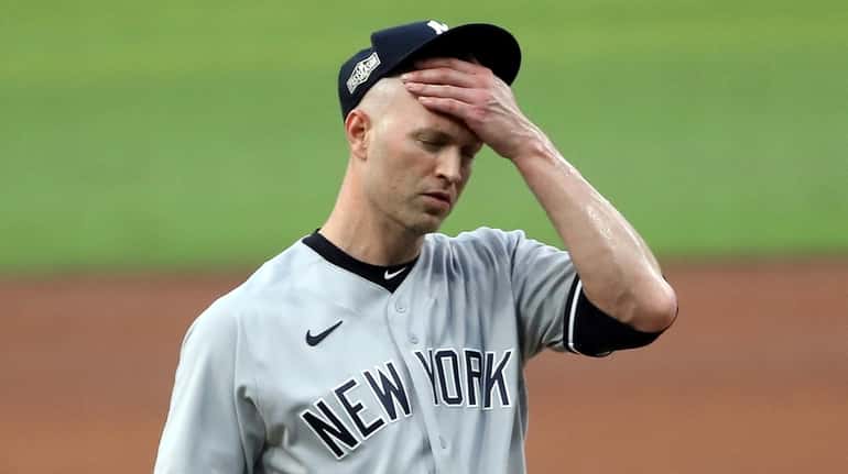 J.A. Happ of the Yankees reacts after allowing a two run home...