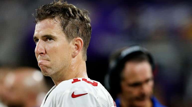 New York Giants quarterback Eli Manning watches form the sidelines...