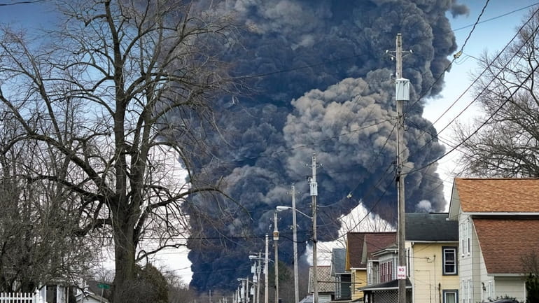 A black plume rises over East Palestine, Ohio, as a...