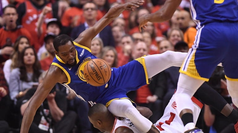 Golden State Warriors forward Kevin Durant, left, tumbles over Toronto...