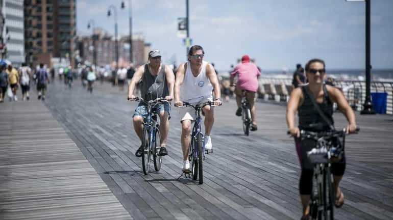 People take to the boardwalk in Long Beach on the...