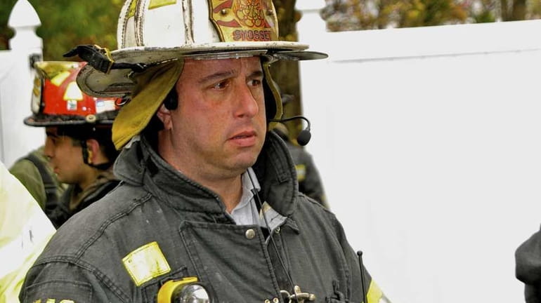 New Syosset Fire Department Chief Robert Kaplan listens to radio...