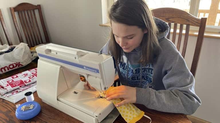 Ada Bieler, a student at Choteau High School in Montana, sews a...