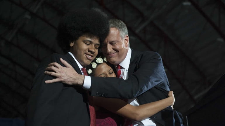 Mayor-elect Bill de Blasio hugs his daughter Chiara and son...