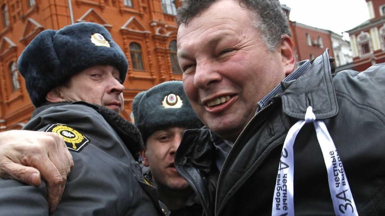 Russian police officers detain opposition activist Mikhail Kruger during an...