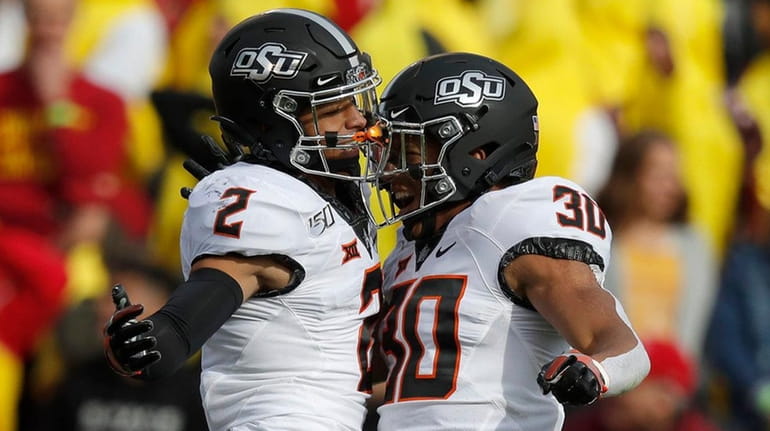 Oklahoma State wide receiver Tylan Wallace, left, celebrates his touchdown...