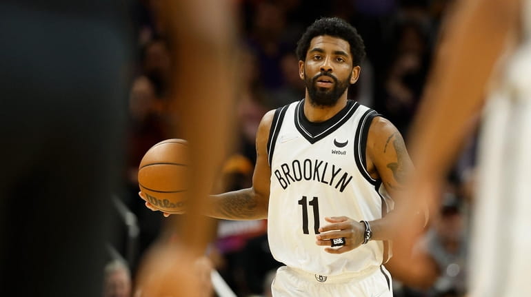 Kyrie Irving of the Brooklyn Nets handles the ball against...