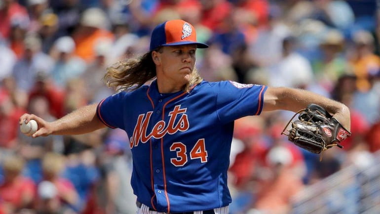 Noah Syndergaard throws during the first inning of a spring...