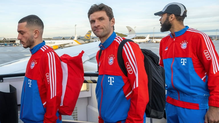Thomas Mueller, center, and Eric Maxim Choupo-Moting, right, players of...