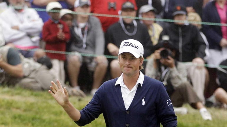 Webb Simpson waves after chipping on the 18th hole during...