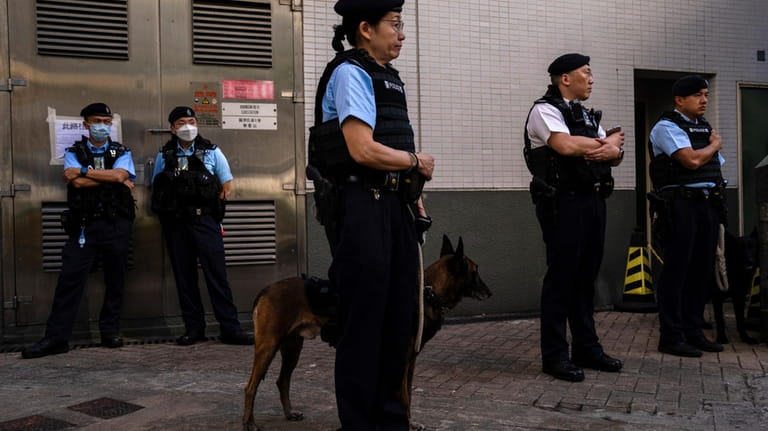 Police officers patrol outside a polling station during the District...