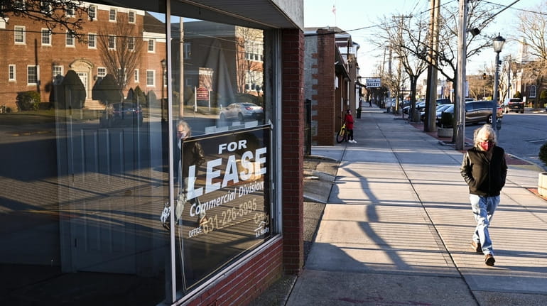 A person walks past a vacated storefront along Wellwood Avenue...