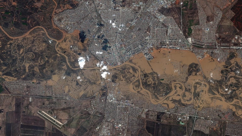 This image provided by Maxar Technologies, shows flooded areas in...