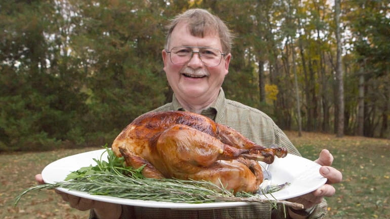 Chef John Ross holds a a slow-roasted, brined turkey with...
