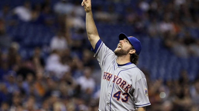 Mets starting pitcher R.A. Dickey points to the ball as...