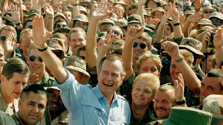 President George H.W. Bush visits with soldiers at an air...