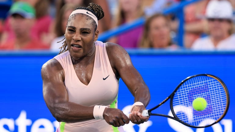 Serena Williams hits a backhand to Emma Raducanu during the...