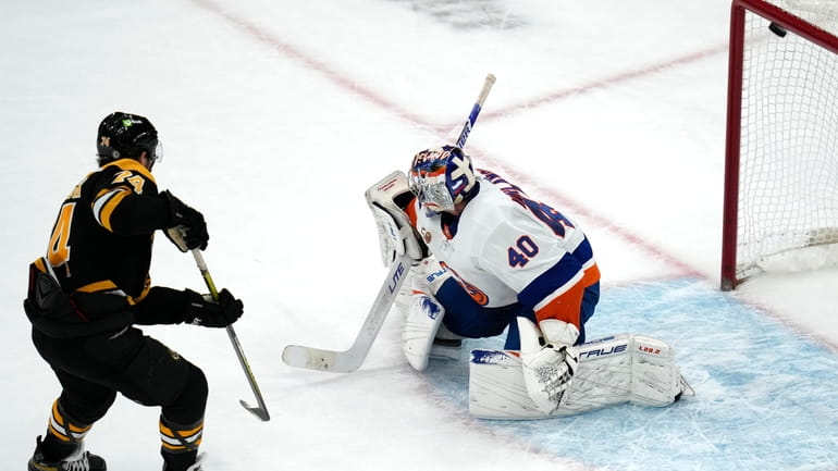 Boston Bruins left wing Jake DeBrusk (74) scores on Islanders goaltender...