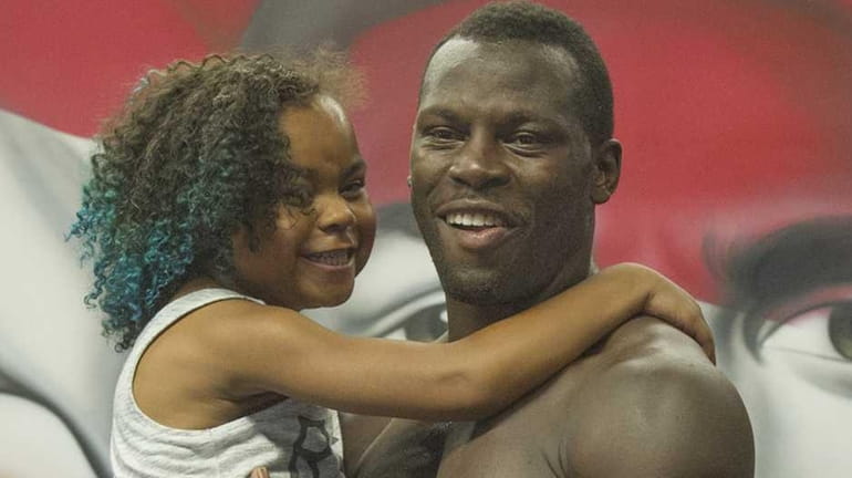 Philadelphia heavyweight boxer Steve Cunningham holds his 9-year-old daughter, Kenned,y...