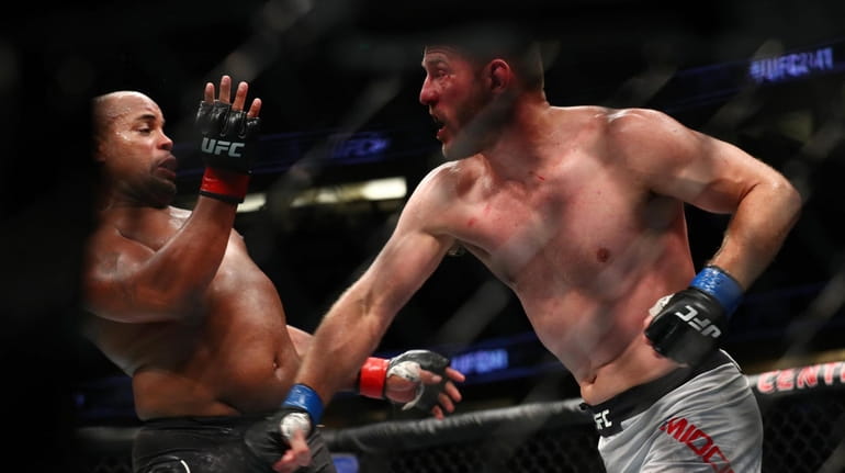Stipe Miocic throws a punch at Daniel Cormier in the...