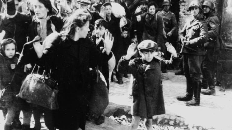 Jews being held at gunpoint by German SS troops during...