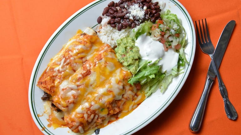 Beef enchiladas served with rice and beans, guacamole, sour cream...