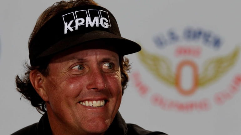 Phil Mickelson speaks with the media during a practice round...