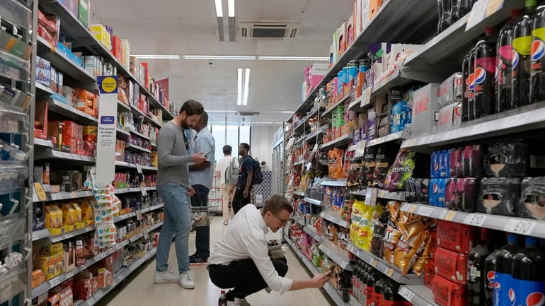 Shoppers buy food in a supermarket in London, on Aug....