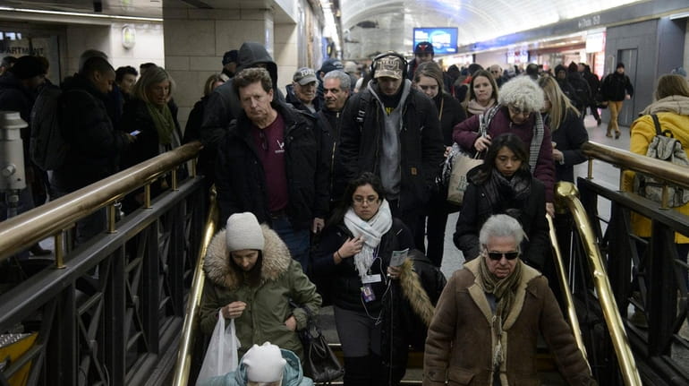 Commuters at Penn Station take the stairs to a Long...