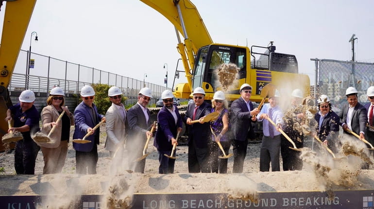 Officials and others gather to break ground Tuesday on the Superblock...
