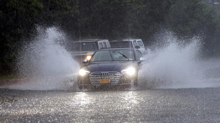 Drivers navigate a flooded Commercial Boulevard as heavy rain moves...