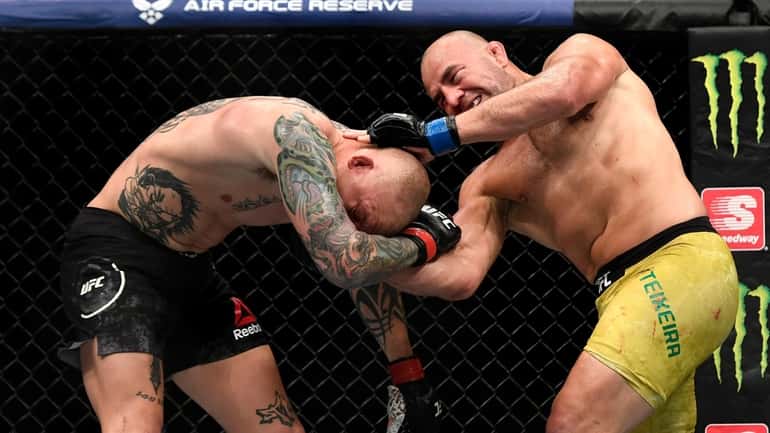 Glover Teixeira (R) of Brazil fights Anthony Smith (L) of...