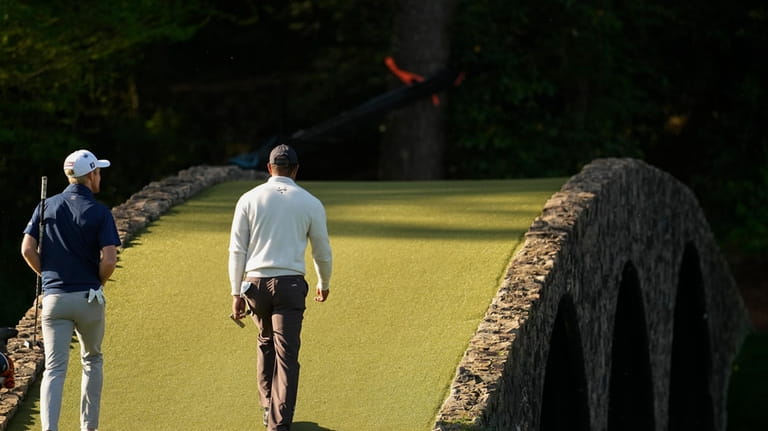 Will Zalatoris, left, and Tiger Woods walk on on the12th...