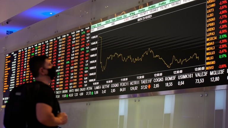 A visitor looks at stock price monitors at the B3...