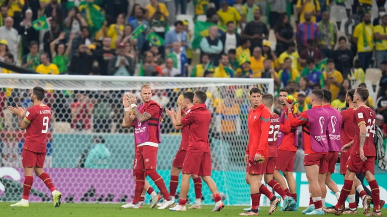 Serbia's players leave the pitch at the end of the...