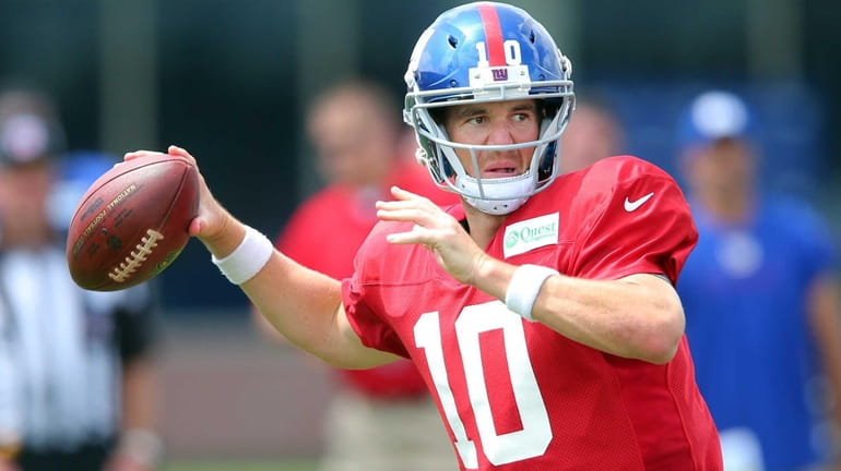 Giants quarterback Eli Manning drops back to pass during training...