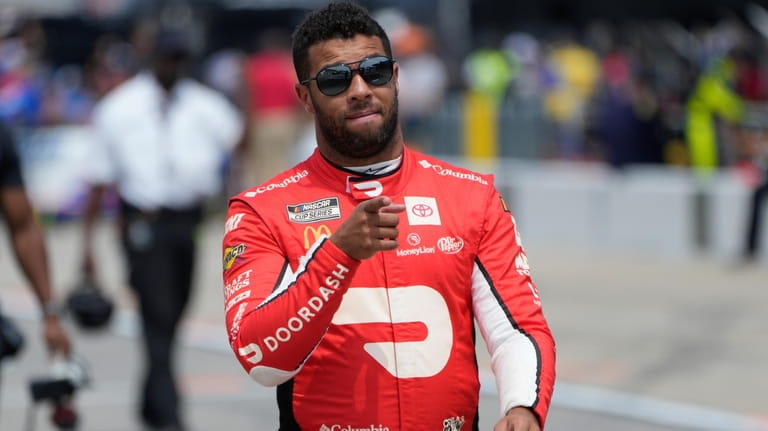 Bubba Wallace walks to his car during qualifications for a...