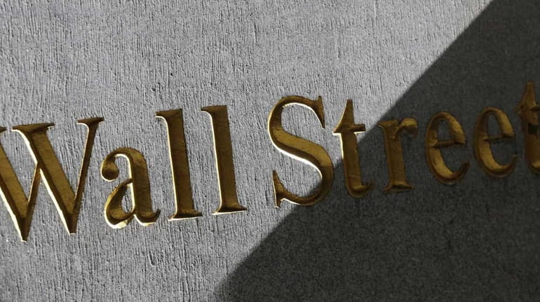 A Wall Street sign is seen on the side of...