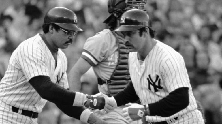 Yankees catcher Thurman Munson, right, is congratulated by teammate Reggie...