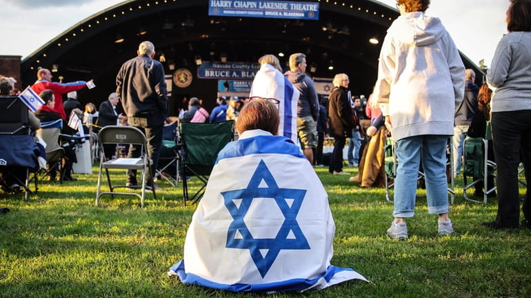 Judith Powell of North Bellmore sits with an Israeli flag...