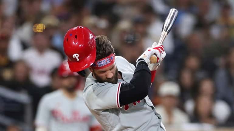 Philadelphia Phillies' Bryce Harper reacts after being hit by a...