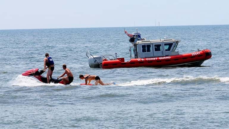 Life guards search for missing swimmers in Long Beach. Four...