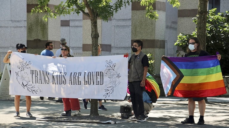 LGBTQ+ rights supporters rally in support of transgender youth outside...