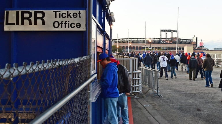 Baseball fans walk from the Mets-Willets Point LIRR station in...