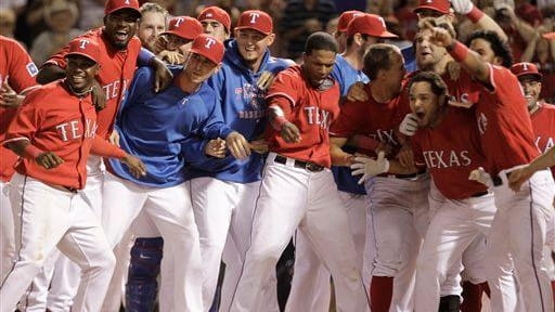 The Texas Rangers gather around home plate waiting to greet...
