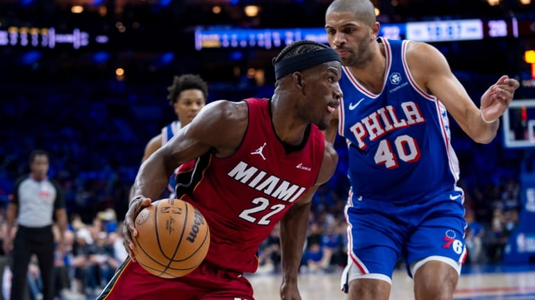 Miami Heat's Jimmy Butler, left, drives to the basket against...