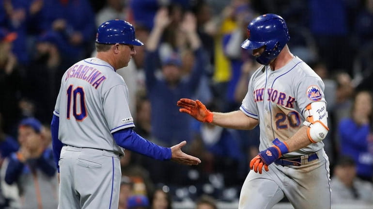The Mets' Pete Alonso, right, is greeted by third-base coach...