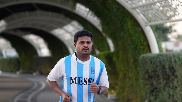 A fan in a Messi jersey runs at Al Gharafa...