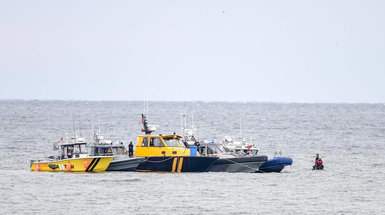 Rescuers search the waters off Quogue on Sunday.